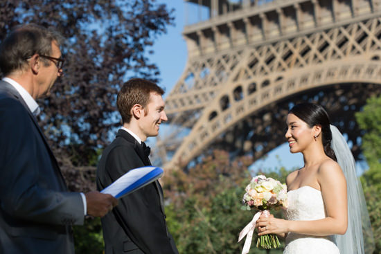 An officiant conducting an intimate wedding at the foot of the Eiffel Tower.