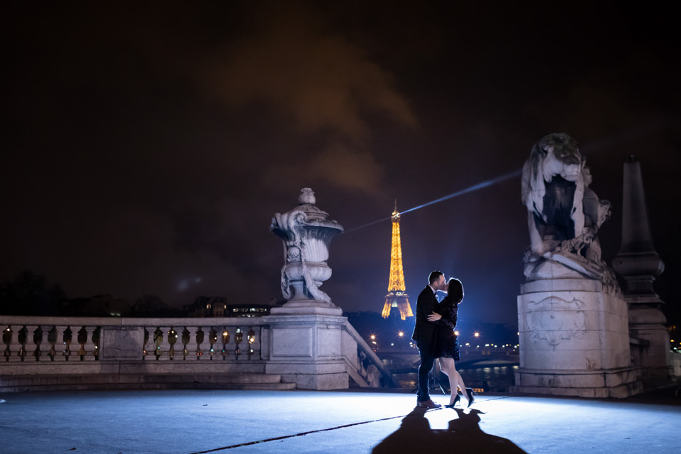 Couple kissing on Alexander III bridge in Paris by night