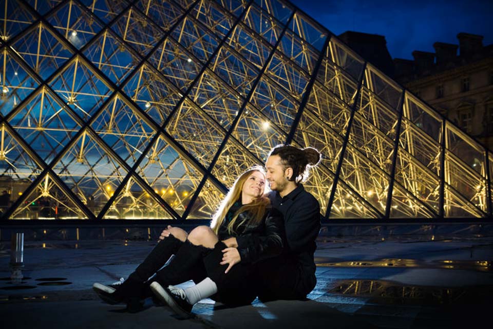 Couple posing at le Louvre Museum by night
