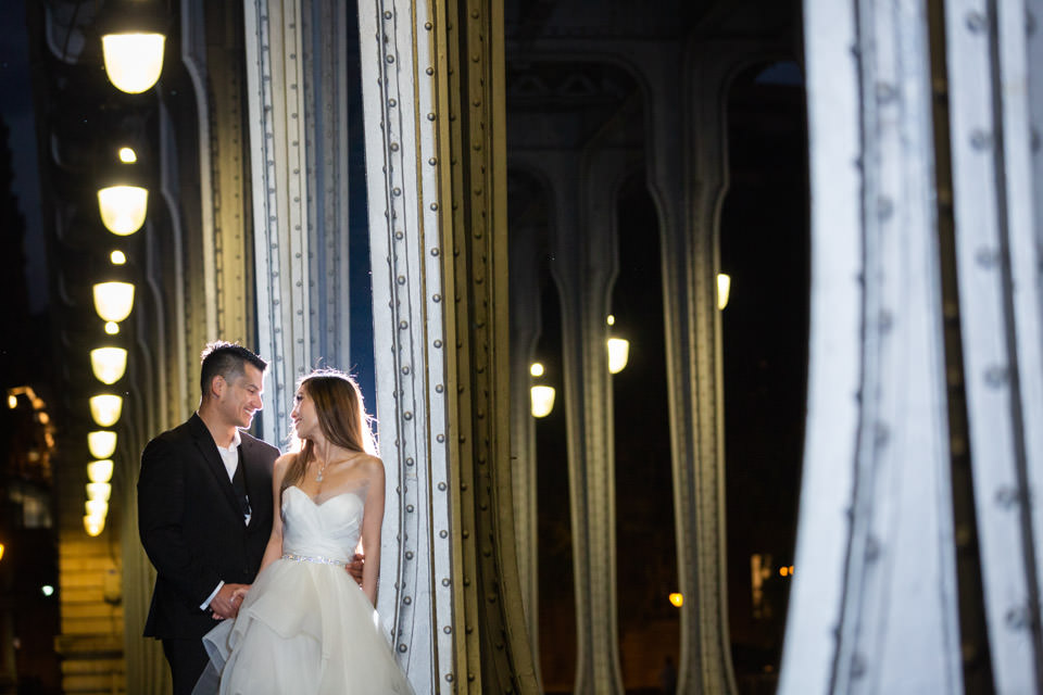 Couple posing at Bir Hakeim bridge at night