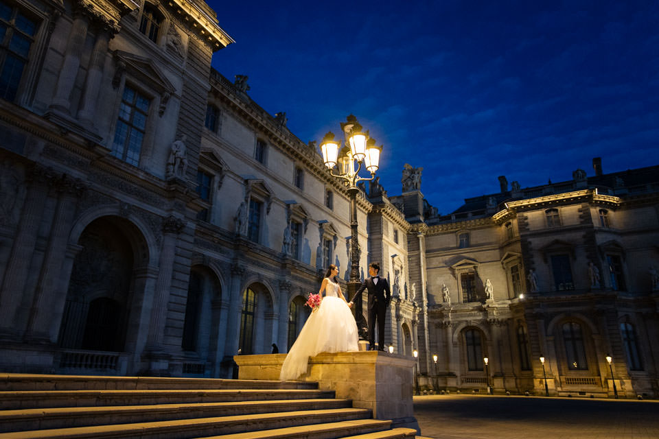 night-photoshoot-in-paris Couple under a streetlight at the Louvre Museum
