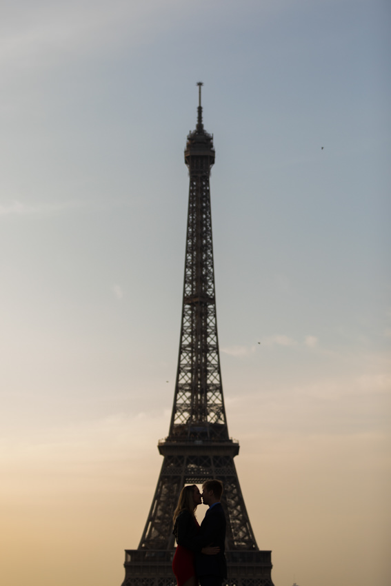 Paris-photographer-eiffel-tower Couple facing each other, positioned in the center of the Eiffel Tower