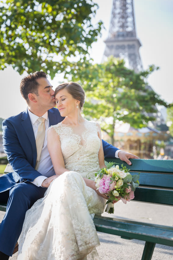 couple-photoshoot-paris Man tenderly kissing his wife on a bench in Paris